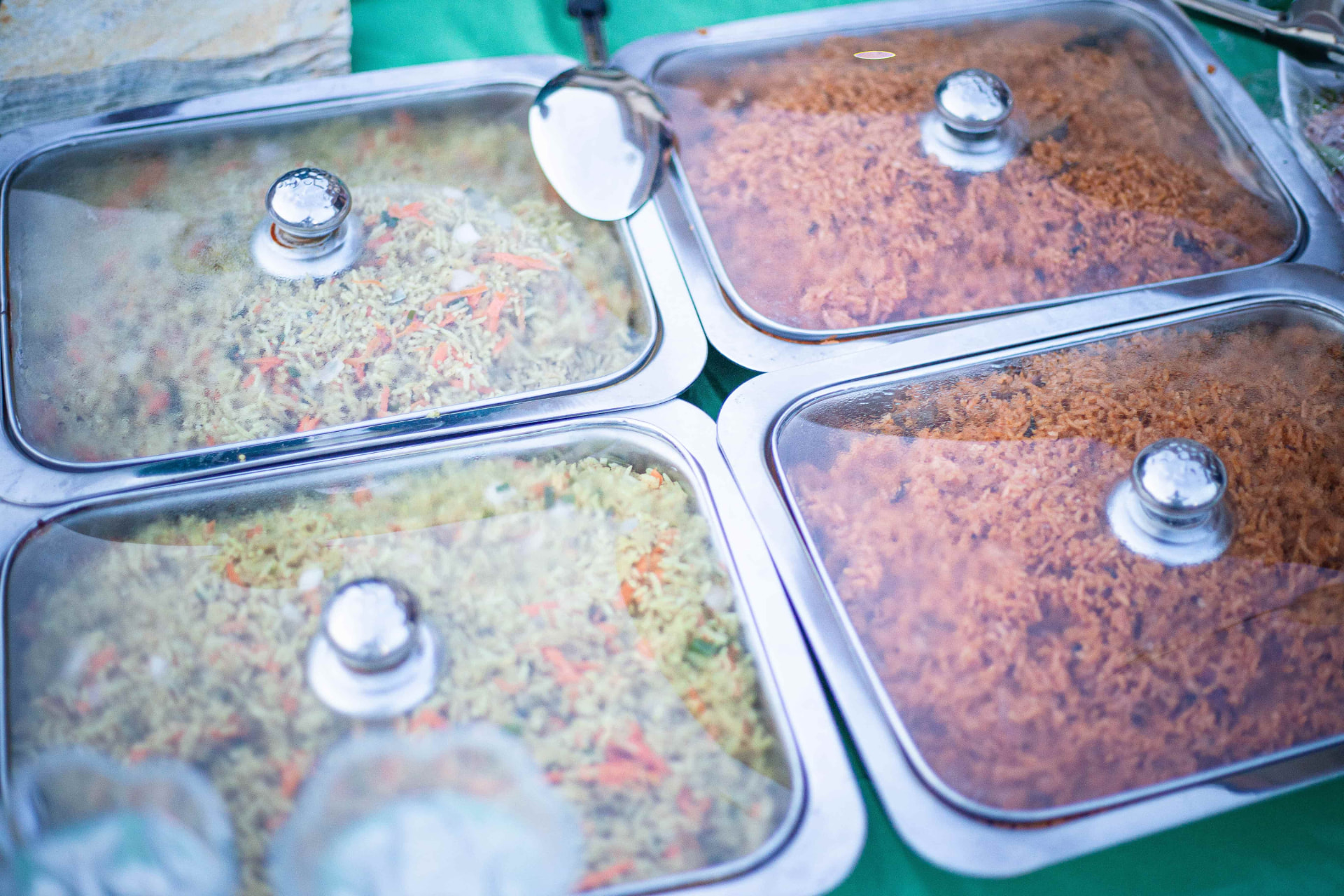 Buffet trays of fried rice and jollof rice at the celebration